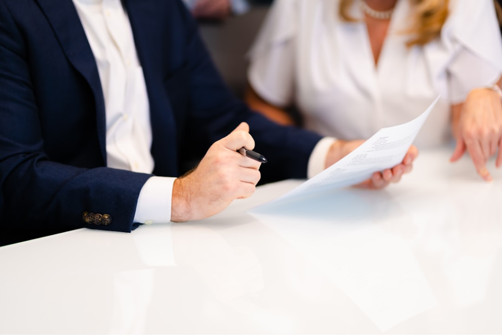 Close-up image of business professionals shaking hands over a table with documents.